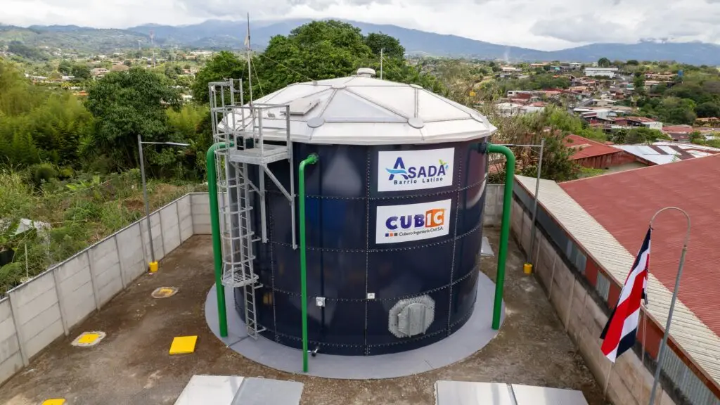 Tanque de acero vitrificado instalado en planta industrial, con estructura robusta y sistema de tuberías conectado.